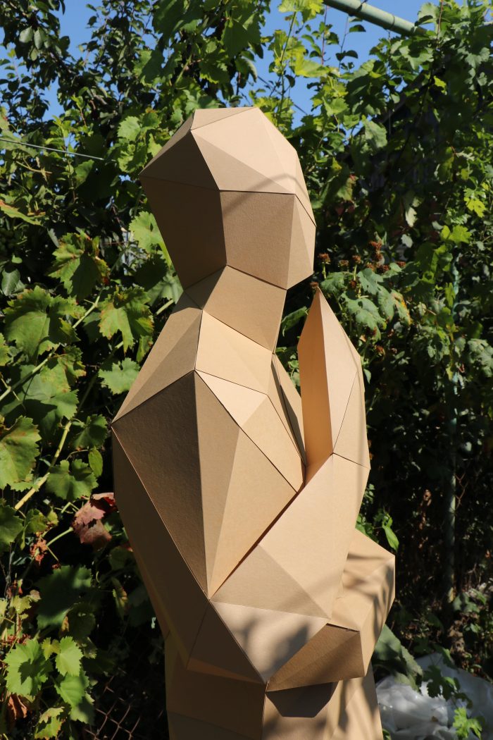 Escultura de un hombre en pleno crecimiento artesanal de papel
